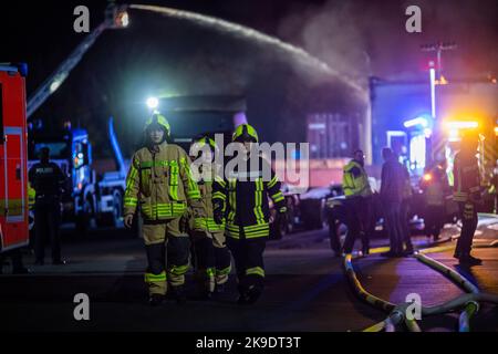 Bad Oeynhausen, Deutschland. 28. Oktober 2022. Junge Feuerwehrleute sind auf dem Gelände eines Entsorgungsunternehmens im Einsatz, in dem die Halle für gefährliche Abfälle in Brand gesetzt wird. (To dpa 'gefährliche Abfallhalle in Bad Oeynhausen in Flammen') Quelle: Lino Mirgeler/dpa/Alamy Live News Stockfoto