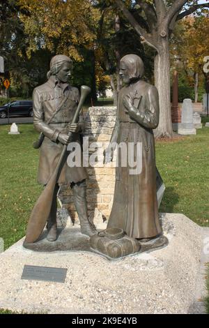 Statue zur Erinnerung an eine Begegnung zwischen einem Händler und einem Priester auf dem Gelände der St. Boniface Kathedrale in Windnpeg, Manitoba, Kanada Stockfoto