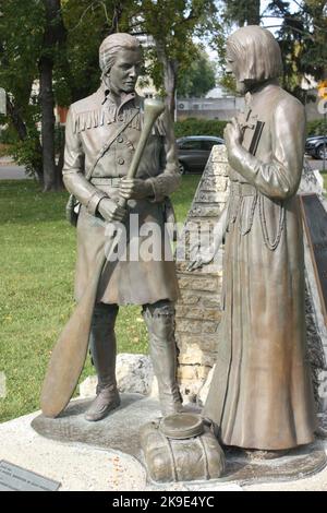 Statue zur Erinnerung an eine Begegnung zwischen einem Händler und einem Priester auf dem Gelände der St. Boniface Kathedrale in Windnpeg, Manitoba, Kanada Stockfoto