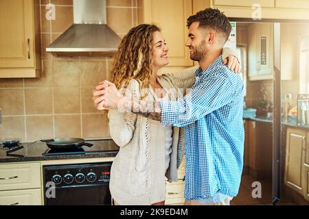 Ein junges Paar, das zu Hause in der Küche tanzte, machte immer etwas Außergewöhnliches. Stockfoto