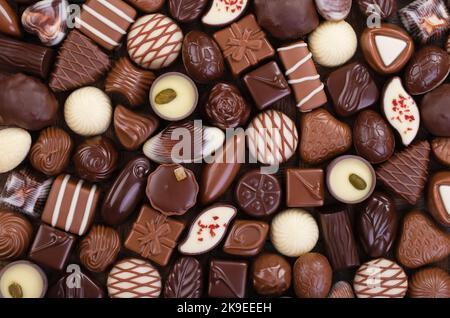 Schokolade Bonbons Hintergrund, süße Lebensmittel mit verschiedenen Füllungen. Stockfoto