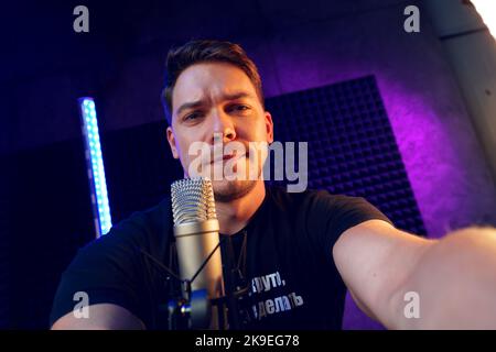 Junger Mann im Aufnahmestudio mit Mikrofon Stockfoto