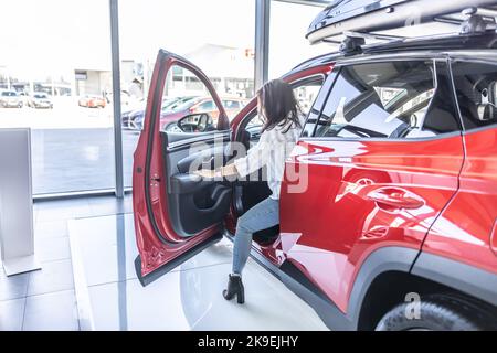 Ein junger Kunde nutzt die Inspektion eines Neuwagens im Laden. Stockfoto