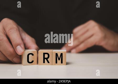 Holzwürfel mit CRM Customer Relationship Management Automatisierungssystem Software Symbol auf Schreibtisch und Kopierraum.Geschäftskonzepte. Stockfoto