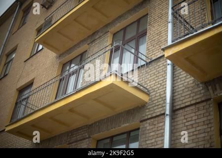 Offene Balkone. Balkone ohne Verglasung im Haus. Details des alten Hauses. Fenster in einer Ziegelwand. Stadtentwicklung des 20.. Jahrhunderts. Stockfoto