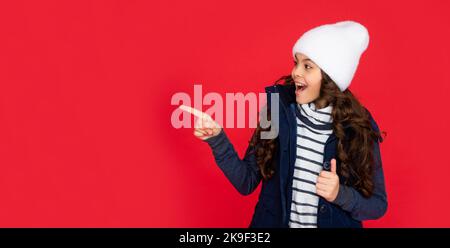 ausdruck positiver Emotionen. Wintermode. Zeigefinger auf Kopierraum. Emotionales Kind Stockfoto