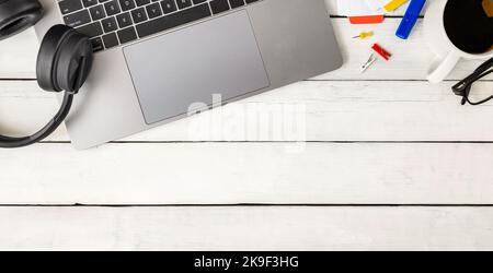 Online Lernen, Arbeiten oder Arbeitsplatzkonzept. Laptop, Kopfhörer, Kaffeetasse, Brillen und Bürobedarf Stockfoto