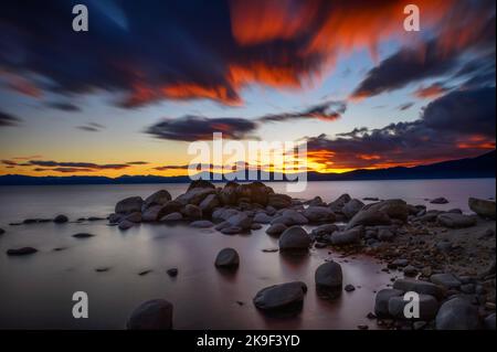 Sonnenuntergang über dem felsigen Strand von Lake Tahoe in Kalifornien Stockfoto