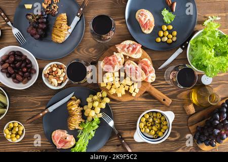 Esstisch mit verschiedenen Speisen und Weinen von oben Stockfoto