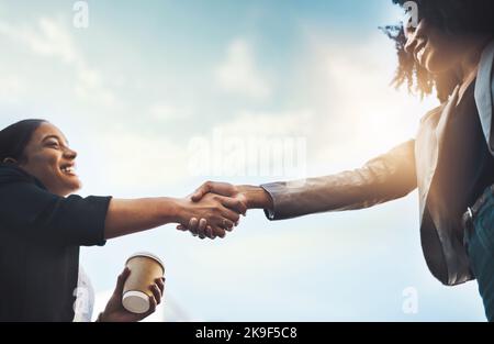 Zwei Geschäftsfrauen, die sich im Freien die Hände schütteln. Stockfoto