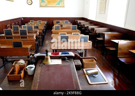 Altes historisches Klassenzimmer mit Holztischen und Tafeln Stockfoto
