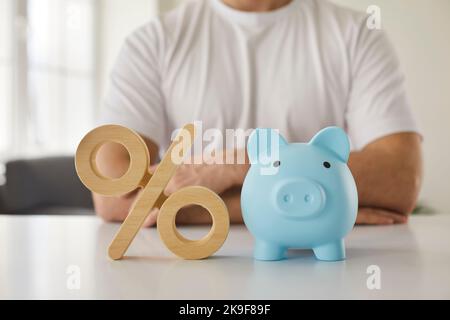 Prozent Zeichen und Sparschwein als Symbol für Zinsen investieren und ansammeln Geld. Stockfoto