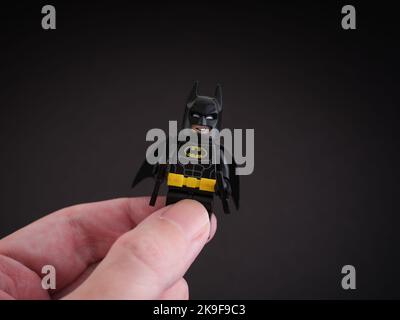 Tambow, Russische Föderation - 09. Oktober 2022 Eine Hand mit einer Minifigur von Lego Batman vor schwarzem Hintergrund. Stockfoto