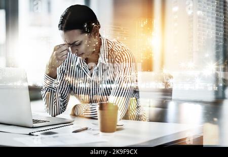 Wie kann ich mich unter all diesem Stress konzentrieren: Eine junge Geschäftsfrau, die gestresst in einem Büro arbeitet. Stockfoto