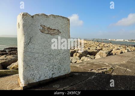 Eine Eichel auf einer Granitplatte, die mit einem Wasserflugzeug auf dem South West Coast Path am Mount Batten Breakwater in Plymouth geschnitzt wurde, erinnert an die Zeiten, in denen es war Stockfoto