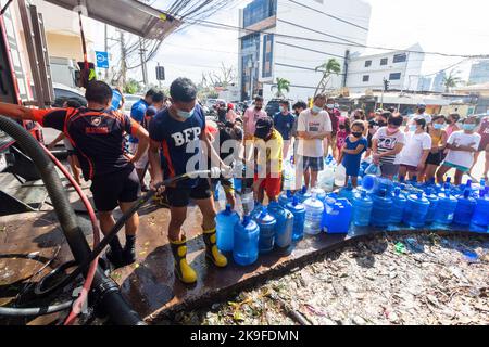 Mitglieder des Bureau of Fire Protection, die den Bewohnern Trinkwasser nach einer Wasserknappheit durch den Taifun Rai in Cebu, Philippinen, zur Verfügung stellen Stockfoto