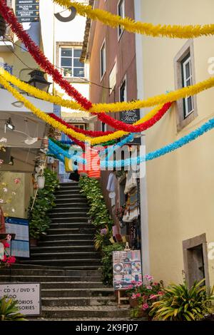 SINTRA, PORTUGAL - 27.. JUNI 2022: Enge Gassen des Dorfes Sintra mit verschiedenen Geschäften, darunter Restaurants und Souvenirs. Stockfoto