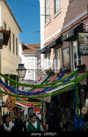 SINTRA, PORTUGAL - 27.. JUNI 2022: Enge Gassen des Dorfes Sintra mit verschiedenen Geschäften, darunter Restaurants und Souvenirs. Stockfoto