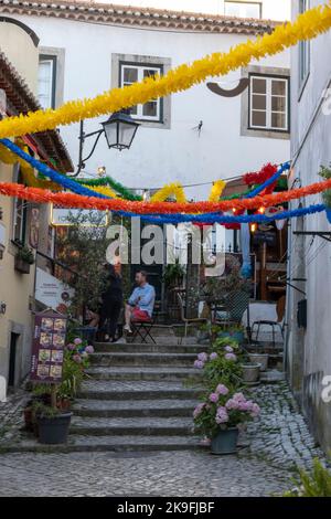 SINTRA, PORTUGAL - 27.. JUNI 2022: Enge Gassen des Dorfes Sintra mit verschiedenen Geschäften, darunter Restaurants und Souvenirs. Stockfoto