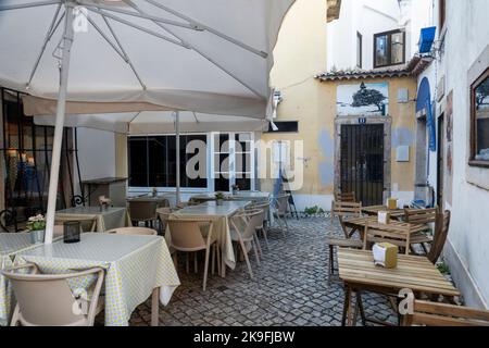 SINTRA, PORTUGAL - 27.. JUNI 2022: Enge Gassen des Dorfes Sintra mit verschiedenen Geschäften, darunter Restaurants und Souvenirs. Stockfoto