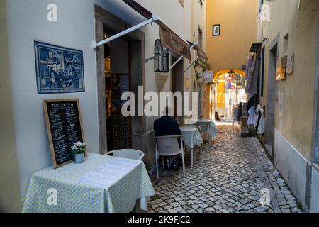 SINTRA, PORTUGAL - 27.. JUNI 2022: Enge Gassen des Dorfes Sintra mit verschiedenen Geschäften, darunter Restaurants und Souvenirs. Stockfoto