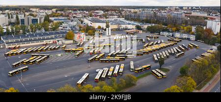 Stadtbild-Panorama. Vogelperspektive über halb gefüllte Busterminus. Busse und Elektrobusse stehen nebeneinander. Vorteile des öffentlichen Nahverkehrs. Hochwertige Fotos Stockfoto