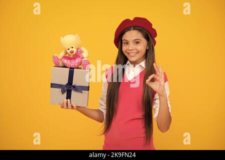 Tween und Jugend. Kaufen Sie ein Geschenk. ok Geste. Glücklich französisch teen Mädchen halten Geschenk-Box. Stockfoto