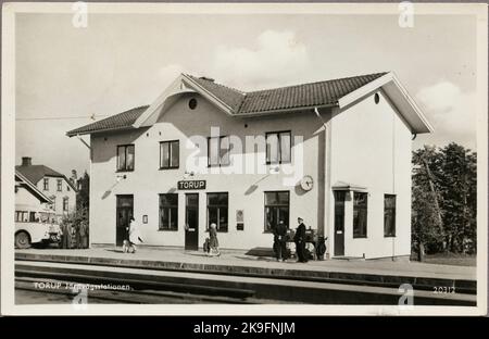 Gleisseite des Bahnhofs mit Reisenden auf dem Bahnsteig und einem Teil des Busses im Hintergrund. Stockfoto