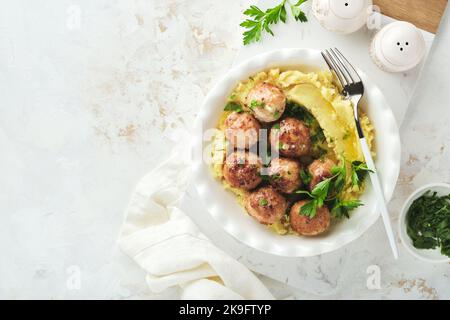 Schwedische Fleischbällchen in Sahnesauce, Kartoffeln und Preiselbeersoße in einer Schüssel auf Schiefer-, Stein- oder Betonböden. Schwedische Küche. Köstliche cremige ma Stockfoto