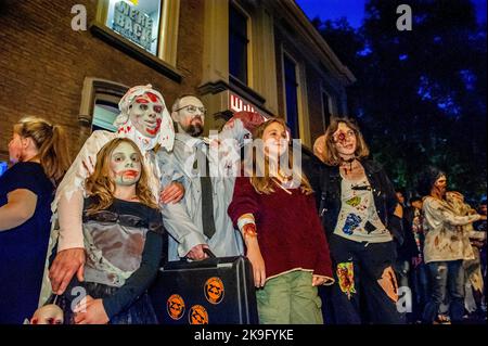 Arnhem, Niederlande. 27. Oktober 2022. Eine Familie, die Zombie-Kostüme trägt, posiert für ein Foto. Auch in diesem Jahr durften die Zombies auf der Suche nach neuen Gehirnen durch die Innenstadt von Arnhem stolpern. Der Spaziergang begann am Live-Musikort „Willemeen“, wo Make-up-Künstler ihr Zombie-Make-up kreisten. Der Zombie Walk findet jedes Jahr am Donnerstagabend vor Halloween statt, denn es ist der einzige Tag der Woche, an dem Geschäfte bis spät in die Nacht geöffnet sind, damit die Menschen die Einkäufe und die Schrecken der Zombies genießen können. Kredit: SOPA Images Limited/Alamy Live Nachrichten Stockfoto