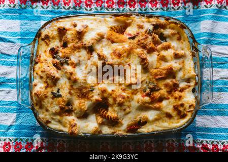 Hausgemachte, im Ofen gebackene Pasta-Auflauf mit frischem Käse. Traditionelles italienisches Gericht „Pasta al forno“ oder „Lasagne“ in Glasbackblech Stockfoto