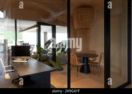 Büroraum mit kurviger Rattan-Installation. Eisballfabrik, Waregem, Belgien. Architekt: Enter Architecture Ltd, 2022. Stockfoto