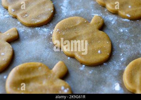 Schneiden Sie Plätzchen aus rohem Kürbisteig auf Backblech aus Stockfoto