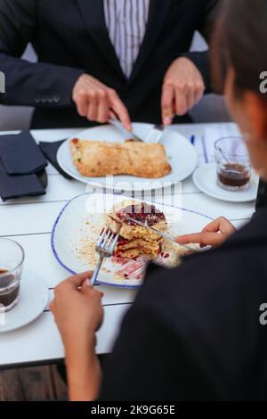 Junge Geschäftsleute genießen an einem sonnigen Tag ein köstliches Frühstück Stockfoto