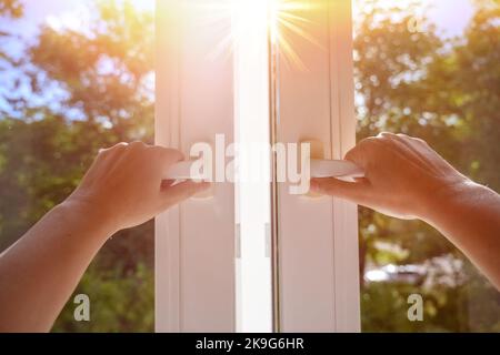 Mann zu Hause Fenster an einem sonnigen Tag öffnen. Manuell öffnen weißen pvc-Kunststoff-Fenster zu Hause Stockfoto