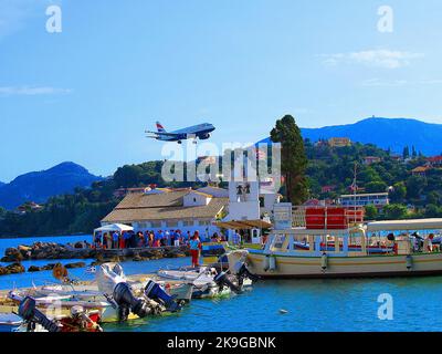 Die Start- und Landebahn des Flughafens ist von Wasser umgeben, was Korfu zu einem der am dramatischsten gelegenen Flughäfen Europas für die Flugbeobachtung macht. Stockfoto