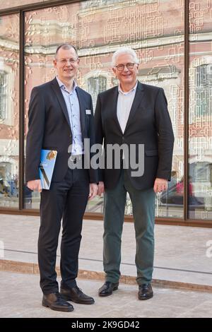 Hamburg, Deutschland. 28. Oktober 2022. Vor dem neuen Besucherzentrum in der Kirche St. Michaelis (Powalla Forum) stehen der Geschäftsführer Thoesten Schulze (l.) und der Oberpfarrer Alexander Röder während der Voreröffnung. Im Hintergrund spiegelt sich ein Teil der Kirche in den gemusterten Scheiben des Besucherzentrums wider. Quelle: Georg Wendt/dpa/Alamy Live News Stockfoto