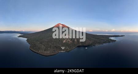 Der Sonnenaufgang beleuchtet die Spitze des Vulkans Lewotolo auf den Kleinen Sunda-Inseln Indonesiens. Diese wunderschöne Region ist Teil des Feuerrings. Stockfoto