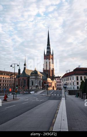 Stockholm, Schweden - 2022. September: Riddarholmen-Kirche und verzierte Turmspitze mit malerischem Blick auf die Straße Stockfoto