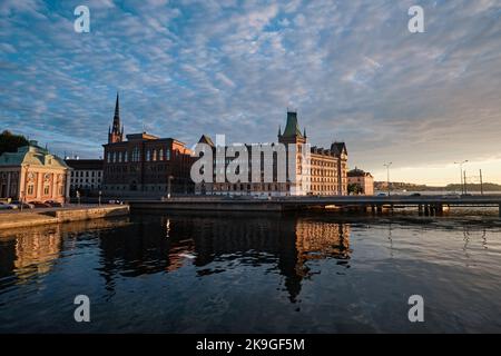 Stockholm, Schweden - 2022. September: Norstedt-Gebäude, Hauptbüro von P.A. Norstedt auf Riddarholmen, Vasabron-Brücke und Gamla Riksarkivet bei Sonnenuntergang Stockfoto