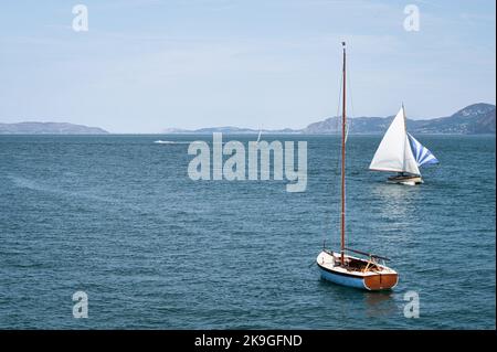 Segelboote auf dem Wasser direkt vor dem Ufer von Beaumaris in Nordwales Stockfoto