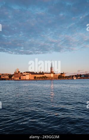 Stockholm, Schweden - 2022. September: Riddarholm Church (Riddarholmskyrkan), Riddarholmen Island und die Altstadt bei Sonnenuntergang Blick auf die Skyline vom Rathaus Wasser Stockfoto