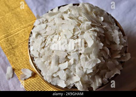 Nahaufnahme von rohem Poha/geschlagenem Reis/abgeflachter Reis in einem Messingbehälter Uruli/Gefäß Stockfoto