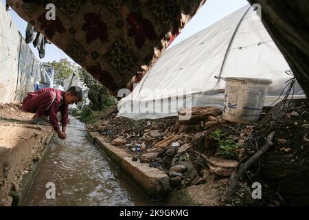 Bebnin, Libanon. 28. Oktober 2022. Ein syrischer Flüchtlingsjunge wäscht sich in einem kontaminierten Wasserkanal in der Nähe ihres Zeltes in einem Flüchtlingslager im nordlibanesischen Dorf Bebnin die Hände. Syrische Flüchtlinge in Vertreibungslagern werden Opfer eines Choleraausbruchs im Libanon, der bereits unter einer wirtschaftlichen Kernschmelze leidet, die den Zugang zu sauberem Wasser eindämmert und Krankenhäuser belastet hat. Quelle: Marwan Naamani/dpa/Alamy Live News Stockfoto