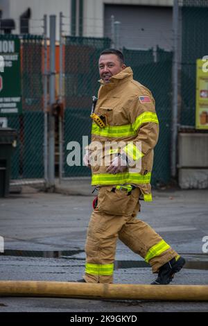 Ein Feuerwehrmann bei einem Industriebrand Stockfoto