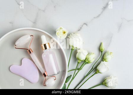 Set von kosmetischen Produkten für die Gesichtspflege. Flach Lay Zusammensetzung mit Feuchtigkeitscreme oder Kollagen Beauty Serum und Gesicht Massage Roller gua Sha. Gesichtsbehandlung sk Stockfoto
