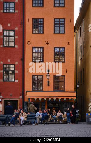 Stockholm, Schweden - 2022. September: Rote und gelbe ikonische Gebäude auf dem Stortorget, einem kleinen öffentlichen Platz mit kleinem Café in Gamla Stan Stockfoto