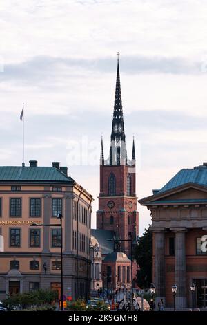 Stockholm, Schweden - 2022. September: Riddarholmen-Kirche und verzierte Turmspitze mit malerischem Blick auf die Straße Stockfoto