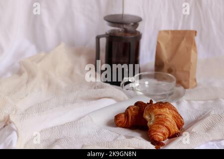 Croissants und Kaffee in einer french Press Kaffeemaschine für ein einfaches französisches Frühstück Stockfoto