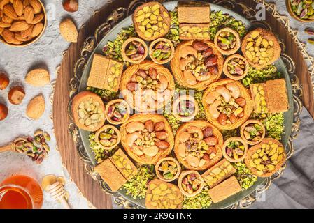 Arabische Küche: Desserts aus dem Nahen Osten. Köstliche Sammlung von traditionellen Ramadan Desserts. Serviert mit leckeren Nüssen, Honigsirup und Zuckersirup. Stockfoto